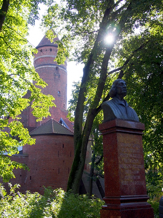 popiersie Mikołaja Kopernika na tle zamku Kapituły Warmińskiej w Olsztynie