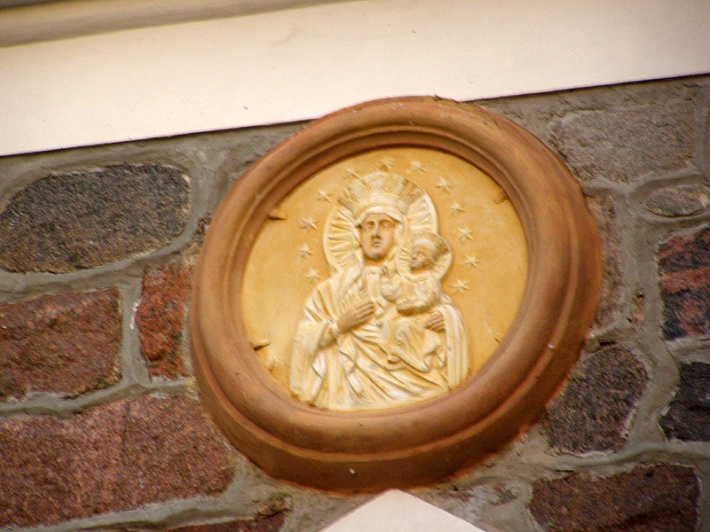 Puńsk - medalion z płaskorzeźbą MB Częstochowskiej nad portalem kościoła