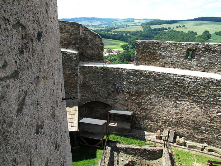 zamek Bolków - mur kurtynowy dziedzińca wewnętrznego z widoczną wnęką po pierwotnej bramie, na dole ogrodzona cysterna na wodę