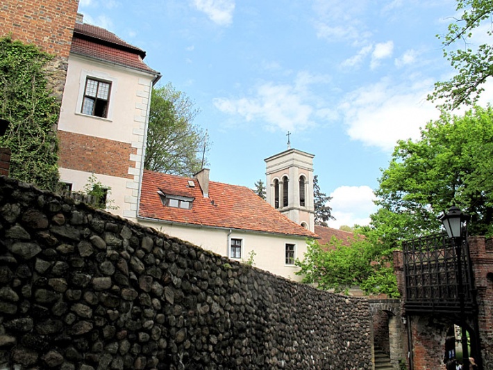 Łagów - mur kurtynowy zamku, baszta bramna i szyja, z prawej brama wjazdowa, na środku kościół św. Jana Chrzciciela
