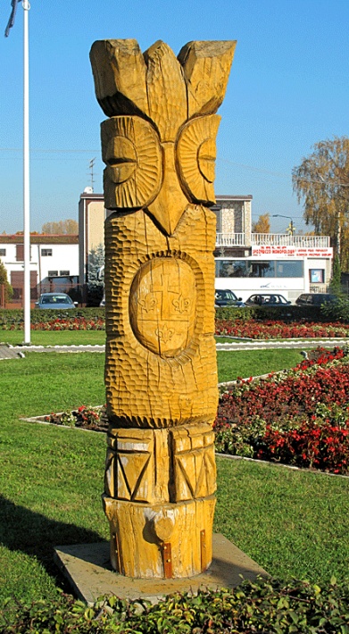 Rynek w Piątku - ludowa rzeźba przedstawiająca sowę z herbem gminy Piątek, lilie pochodzą z herbu arcybiskupstwa gnieźnieńskiego